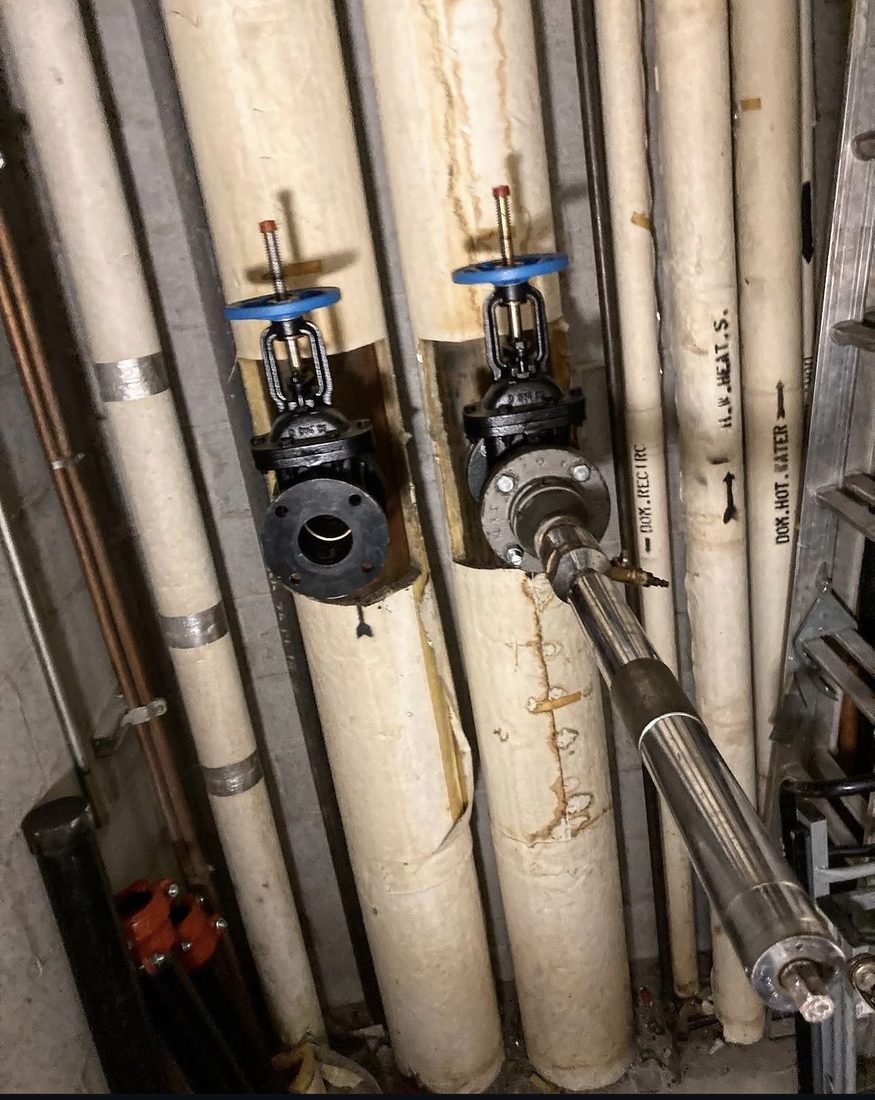 Tapping equipment installed between vertical insulated risers in a mechanical space