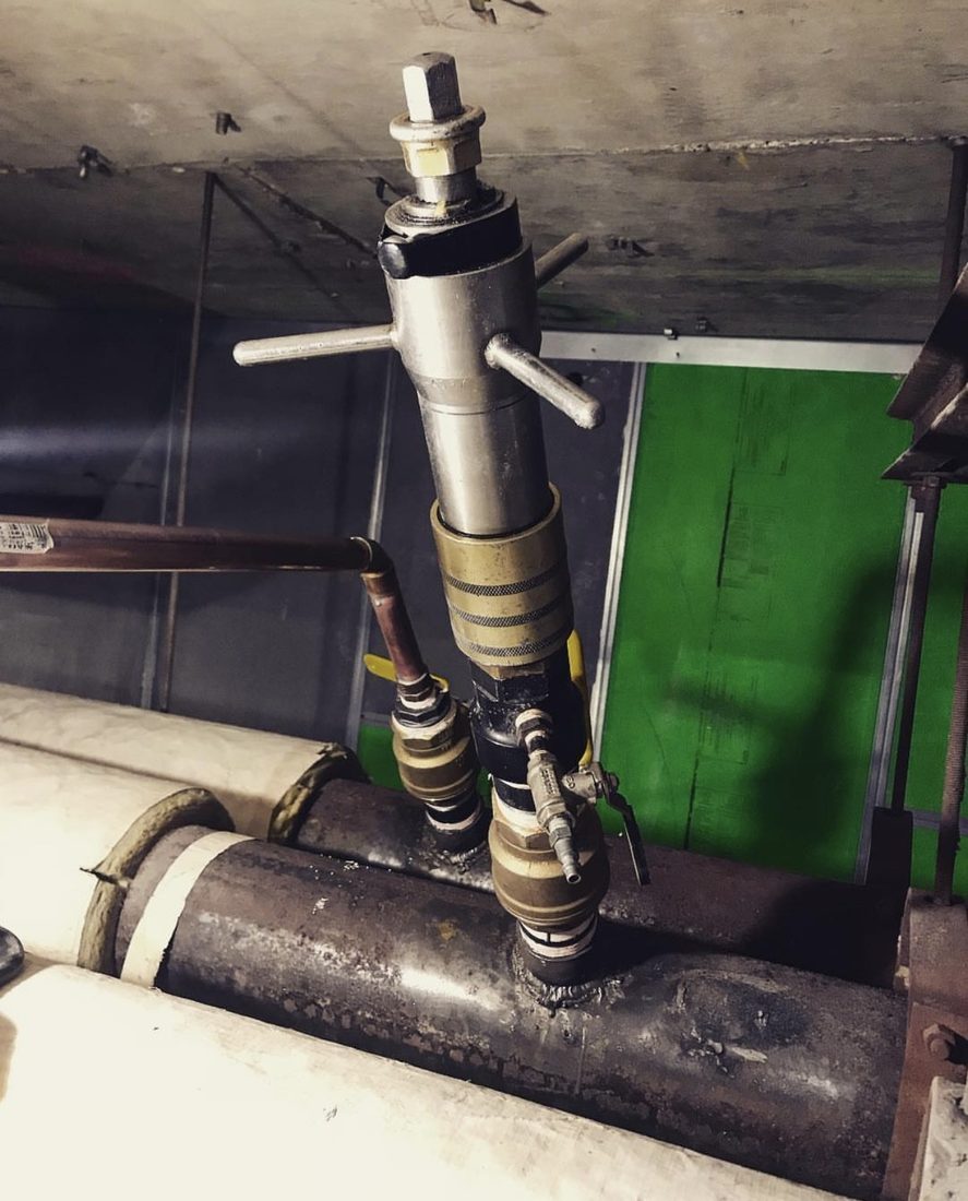 Tapping machine mounted vertically on an in-service steel pipe